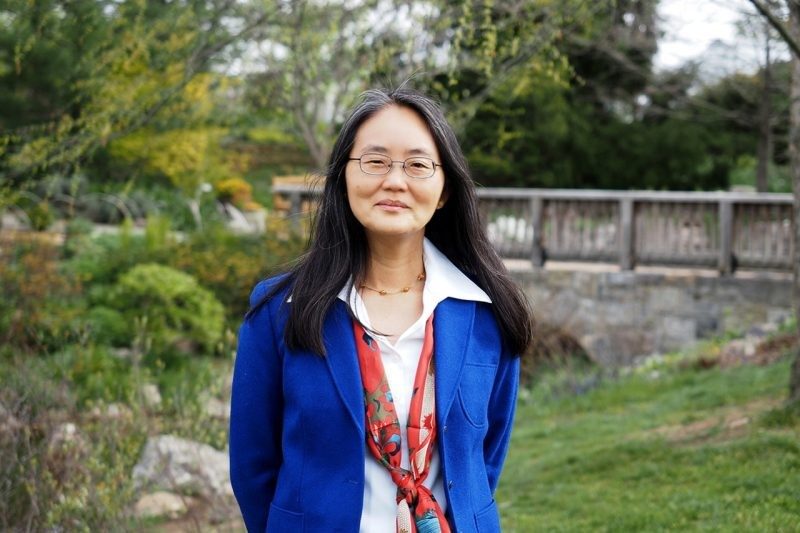 Image of Dr. Su Fang Ng standing outside wearing a blue jacket and glasses