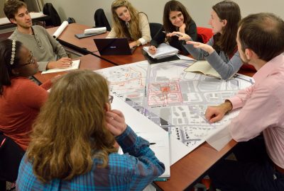 Picture of students and their professor in a classroom in active discussion