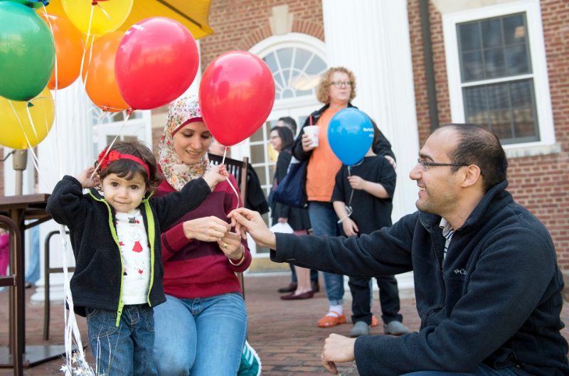 a father giving a small boy a balloon on the steps of the GLC during a Bring your Child to Work event